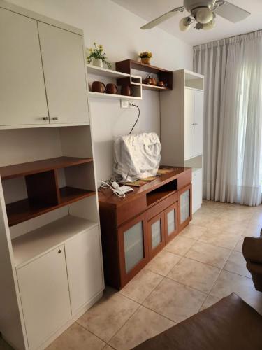 a kitchen with white cabinets and a desk in a room at Miramar in Miramar