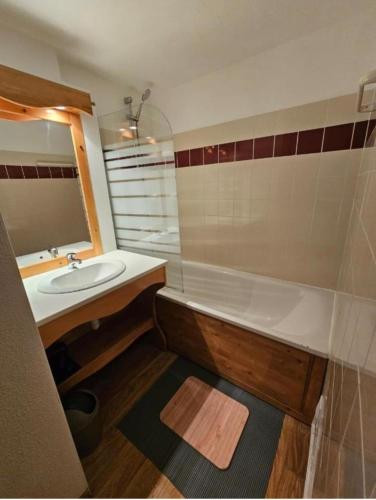 a bathroom with a sink and a tub and a mirror at DFJ des Neiges, Piscine, Pieds des pistes in Chamrousse