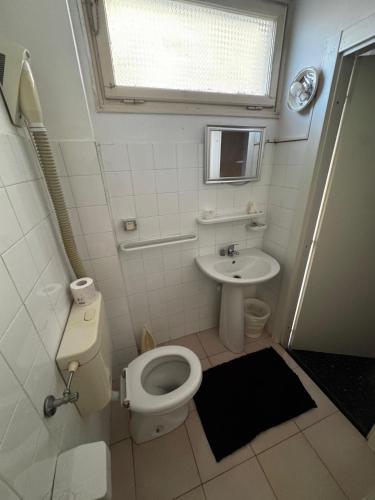 a small bathroom with a toilet and a sink at Hotel & Trattoria Le Caravelle in Lavagna