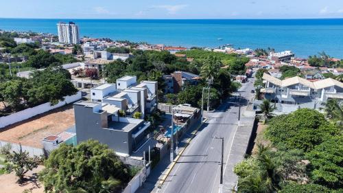 an aerial view of a city with houses and the ocean at Altos do Caju - Triplex in Pirangi 300 meters from the World's Largest Cashew Tree by Carpediem in Parnamirim