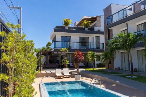 a villa with a swimming pool in front of a building at Altos do Caju - Triplex in Pirangi 300 meters from the World's Largest Cashew Tree by Carpediem in Parnamirim