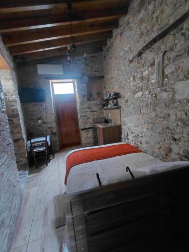 a bedroom with a bed in a stone wall at lefkara stone nest in Pano Lefkara