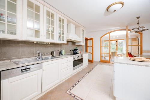 a kitchen with white cabinets and white appliances at Villa Cetatuia in Cluj-Napoca