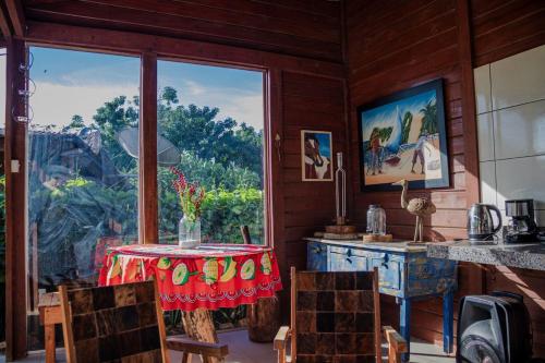 a dining room with a table and a large window at Chalé com Piscina - Festival de Inverno de Bonito in Bonito