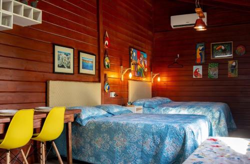 a room with two beds and a table and chairs at Chalé com Piscina - Festival de Inverno de Bonito in Bonito