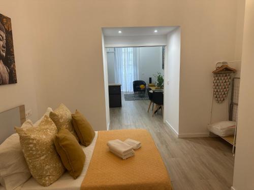 a living room with a bed with pillows on it at Apartamento Vinoble Jerez in Jerez de la Frontera
