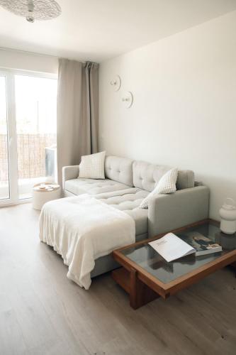 a white living room with a couch and a coffee table at Luxurious Suite - Train Station Deinze in Deinze