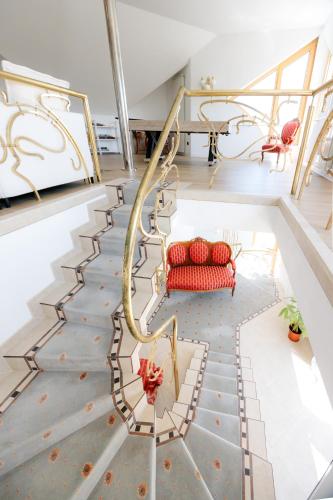 a room with a staircase with red chairs at Villa Cetatuia in Cluj-Napoca