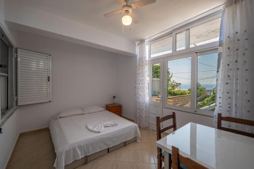 a bedroom with a bed and a table and a window at Vida House in Borsh