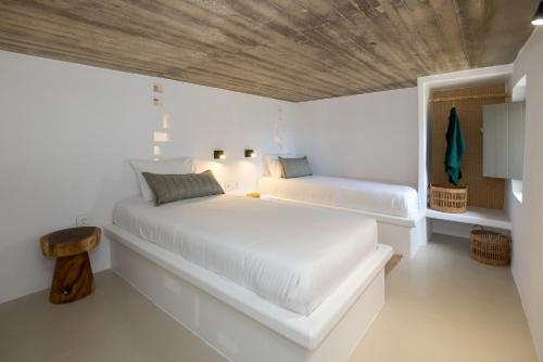 a bedroom with a large white bed with a wooden ceiling at Antara in Stení