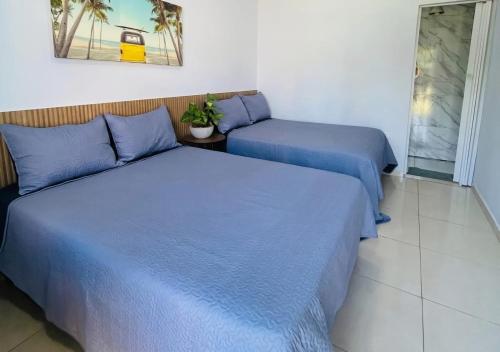 two beds in a room with blue sheets at IMPERIAL BEACH ENSEADA 500 Metros Praia Enseada Gjá Av Professor João Batista Julião x Antonio Del Nero Enseadas jardim Virgínia Bairro Nobre in Guarujá