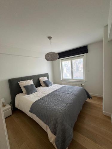 a bedroom with a large bed with a window at C-Blanche in Blankenberge