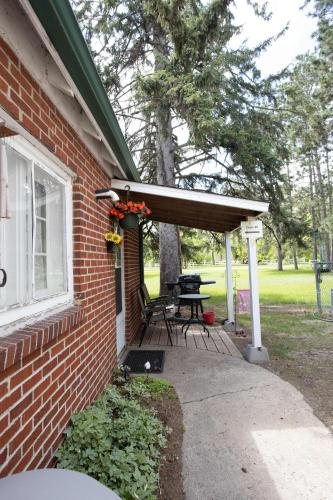 a brick house with awning and a picnic table on a patio at Studio Loft #9 at Riverside Point Resort in Park Rapids