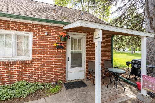 a brick house with a white door and a patio at Studio Loft #9 at Riverside Point Resort in Park Rapids