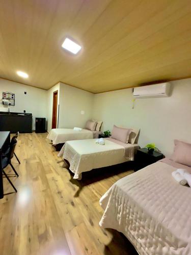a hotel room with three beds and a couch at Tiny House Londres, Timbó in Timbó