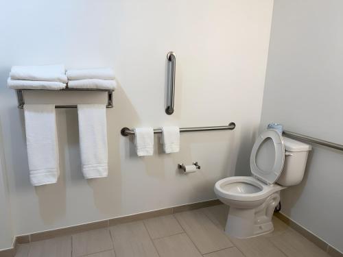 a bathroom with a white toilet and towels at Garner Hotel Pecos by IHG in Pecos