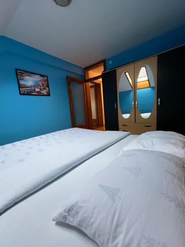 a large white bed in a room with blue walls at Paradiso 5 in Bratunac