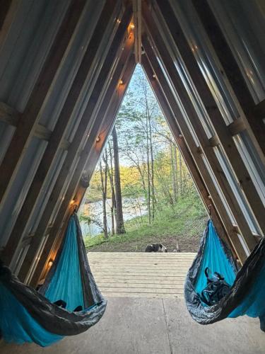 two hammocks in a tent with a view of a river at The Outside Inn in Cullowhee