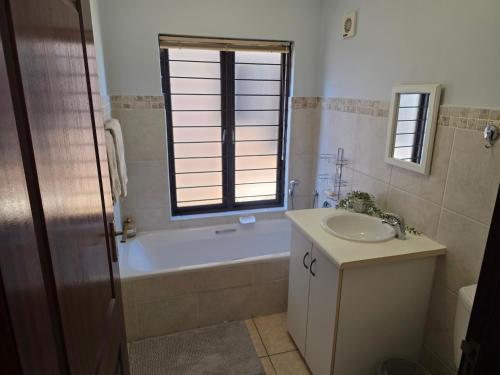 a bathroom with a tub and a sink and a bath tub at 15 Surabaya in Margate