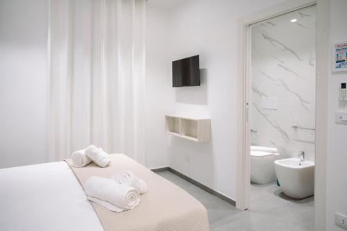 a white bathroom with a bed and a sink at Orizzonte Blu in Villa San Giovanni