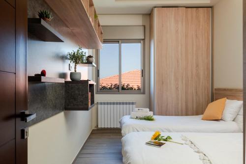 a hotel room with two beds and a window at Brummana Views in Broummana