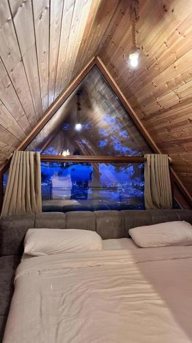 a bed in a room with a large window at Dajti Alpin Villas in Tirana
