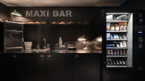 a kitchen with a counter with a cash register and a bar at Ruby Coco Hotel Dusseldorf by IHG in Düsseldorf