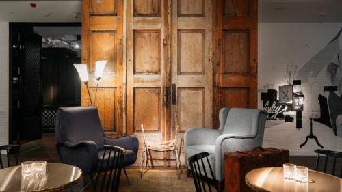 a room with two chairs and tables and a door at Ruby Coco Hotel Dusseldorf by IHG in Düsseldorf