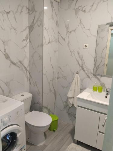 a bathroom with a white toilet and a sink at Apartamento Balsa in Viseu