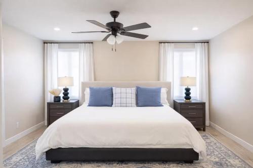 a bedroom with a bed with blue pillows and a ceiling fan at Sequoia Oasis near Downtown Exeter in Exeter