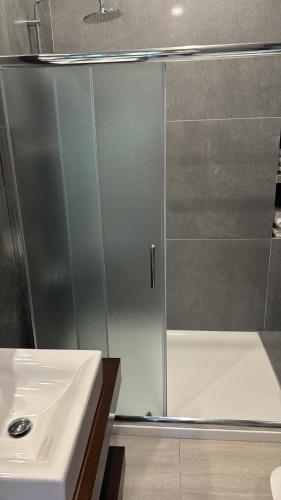 a shower with a glass door next to a sink at Brummana Views in Broummana