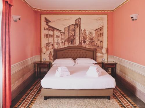 a bed in a room with a painting on the wall at Hotel I Portici in Arezzo