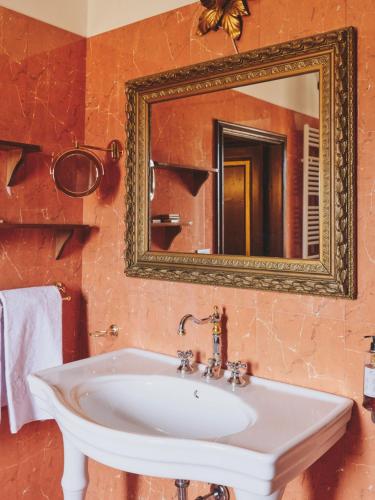 a bathroom with a white sink and a mirror at Hotel I Portici in Arezzo