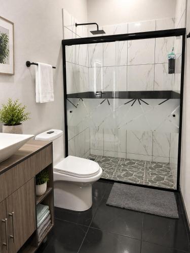 a bathroom with a shower with a toilet and a sink at TinyHouseMX1 Comodidad y playa que se disfruta in San Patricio Melaque