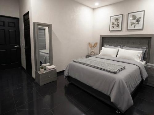 a bedroom with a large bed and a mirror at TinyHouseMX1 Comodidad y playa que se disfruta in San Patricio Melaque
