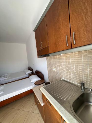 a small kitchen with a bed and a sink at Vila Riviera in Ksamil
