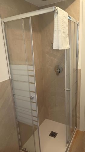 a shower with a glass door and a towel at NaturalmenteLucia 2 in Cologno al Serio