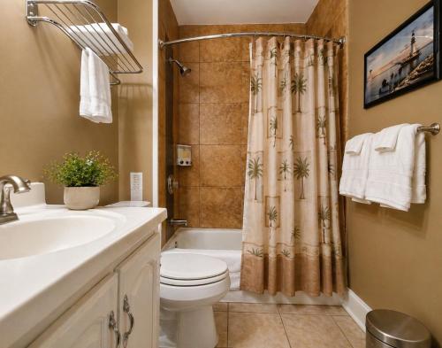 a bathroom with a toilet and a sink and a shower at Spacious Frontier Park Apartment in Erie