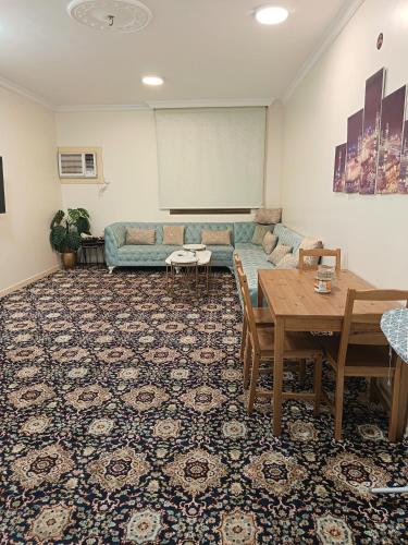 a living room with a couch and a table at شقة العقيق الأولى in Medina