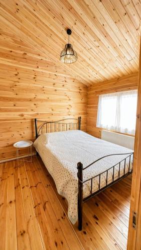 a bedroom with a bed in a wooden cabin at chemtan cottages in Dushetʼi