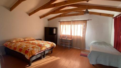 a bedroom with a bed and a window in a room at Cabañas Wiñaypacha Putre in Putre