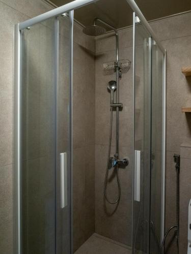 a shower in a bathroom with a glass door at Downtown photographer's studio in Korinthos
