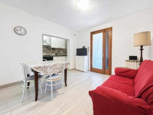 a living room with a red couch and a table at Casa Berso' a Marina di Cecina by Zoom In Earth in Marina di Cecina