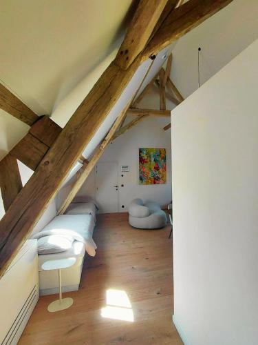 a attic room with a bed and wooden beams at Hoeve De Hemel in Zuienkerke