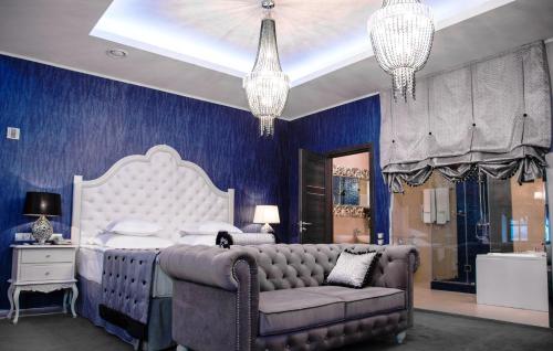 a blue bedroom with a bed and a couch at Author Boutique Hotel (ex Golden Garden Boutique Hotel) in Saint Petersburg