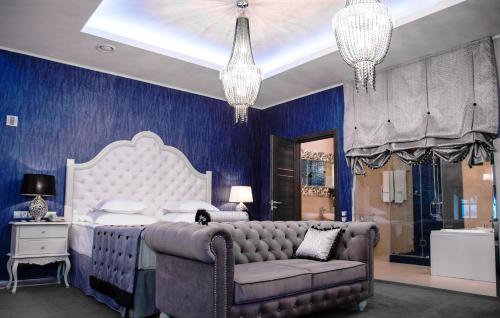 Dormitorio azul con cama y sofá en Author Boutique Hotel (ex Golden Garden Boutique Hotel), en San Petersburgo