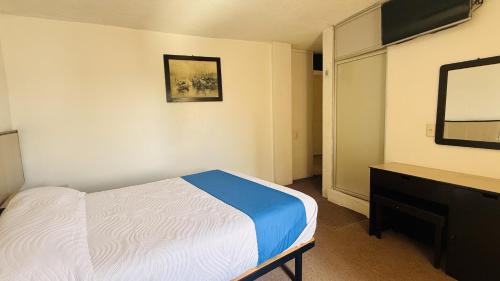 a bedroom with a bed and a dresser and a mirror at Hotel Plaza del Ángel in Huajuapan de León