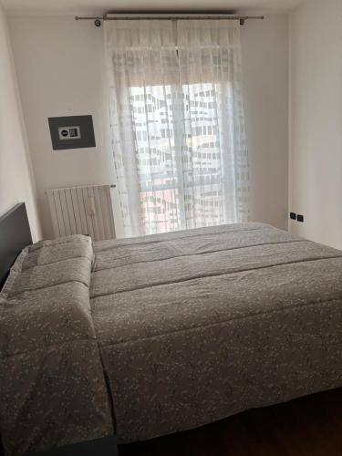 a bedroom with a large bed with a window at Un sogno tra lago e monti in Pescate