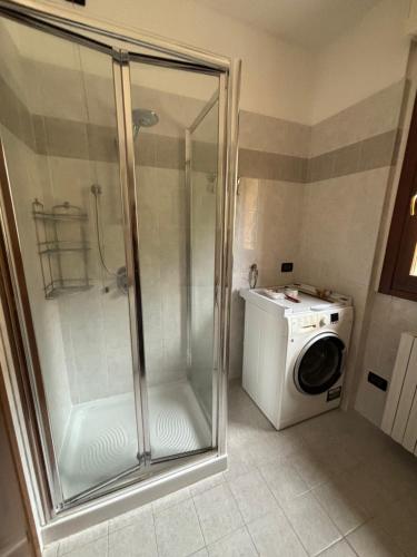 a shower and a washing machine in a bathroom at Un sogno tra lago e monti in Pescate