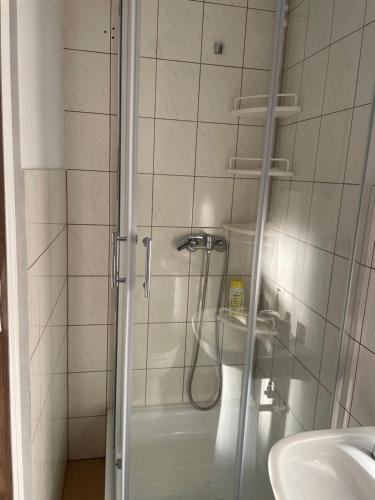 a shower in a bathroom with a sink at Pokój u Patki in Rowy